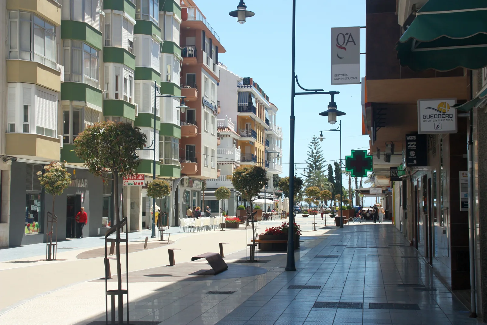 Calle peatonal comercial en el centro de Torre del Mar, con edificios de varias plantas, comercios y terrazas